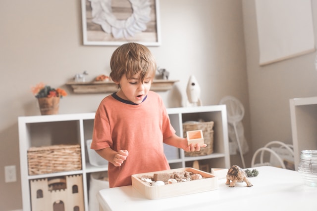 enfant heureux de jouer avec un jeu montessori